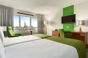 Postel nebo postele na pokoji v ubytování NH Groningen Hotel