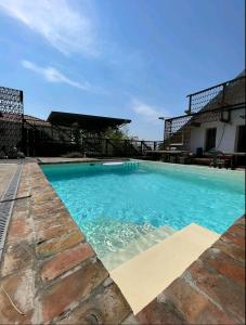 Una piscina con agua azul frente a un edificio. en Train_house_ns, en Petrovaradin