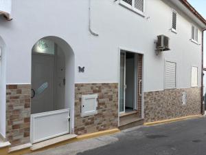 a white building with a door and a window at Il Veliero Bianco in Cala Gonone