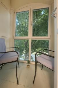 two chairs in a room with a window at Home Sweet Home - Apartament central 2 camere in Craiova
