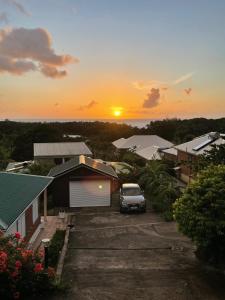 un'auto parcheggiata in un parcheggio con il tramonto sullo sfondo di Villa la mahaudière vue mer a Deshaies