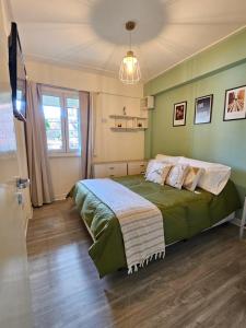 a bedroom with a bed with green walls at Cozy Vibes Apartment Tucumán in San Miguel de Tucumán