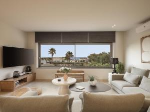 ハニア・タウンにあるVilla Agali I "Free" heated pool & 70m to Sea!のソファと大きな窓のあるリビングルーム
