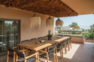 ハニア・タウンにあるVilla Agali I "Free" heated pool & 70m to Sea!のダイニングルーム(長い木製テーブル、椅子付)