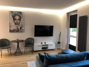 a living room with a couch and a flat screen tv at Komfortowy apartament Osiedle Lecha- garaż podziemny, balkon ,wejście 24h kod ,centrum, targi ,faktura in Kielce