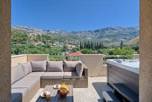 a patio with a couch and a table and a pool at Relax penthouse private jacuzzi Split area in Žrnovnica