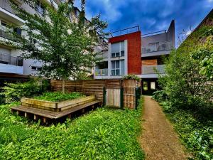 an apartment building with a tree in the yard at Petit Jardin de Paris in Gennevilliers