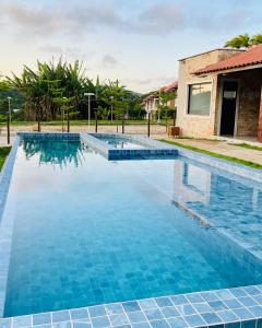 a swimming pool with blue tiles in front of a house at Apartamento 10- Montserrat in Guaramiranga