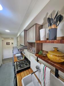 a kitchen with wooden cabinets and a stove top oven at Cozy Vibes Apartment Tucumán in San Miguel de Tucumán