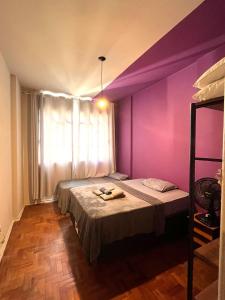 - une chambre avec un mur violet et un lit dans l'établissement Apê Marie I Maletta, Mercado Central e Minascentro, à Belo Horizonte