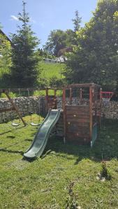 een speeltuin met een glijbaan in het gras bij La Kaifas in Fundata