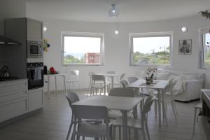 a kitchen and dining room with white tables and chairs at Al Mare da Francesca in Olbia