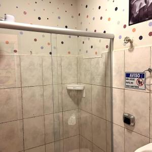 une douche avec une porte vitrée dans une salle de bain dans l'établissement Apê Marie I Maletta, Mercado Central e Minascentro, à Belo Horizonte