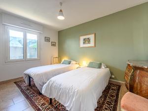 two beds in a room with a window at Apartment Les Voiles by Interhome in La Trinité-sur-Mer