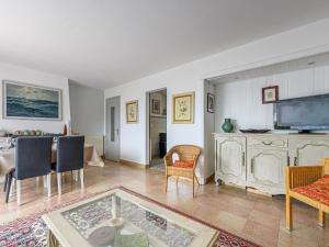 a living room with a tv and a table and chairs at Apartment Les Voiles by Interhome in La Trinité-sur-Mer +17 photos