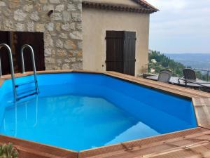 a swimming pool with blue water in front of a house at La villa Haute in Cabris