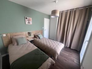 a bedroom with two beds and a window at Maison de vacances entre forêt et plage in Saint-Jean-de-Monts