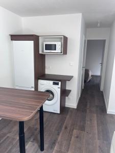 a kitchen with a washing machine and a microwave at Maison de vacances entre forêt et plage in Saint-Jean-de-Monts +13 photos