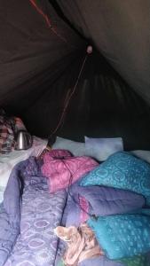 a bed in a tent with blankets and pillows at Kedarnath nandi base camp 2 in Kedārnāth