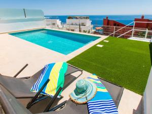 a pair of chairs sitting next to a swimming pool at Apartment Collection View Free Spa & Padel by Interhome in Torrox Costa +50 photos