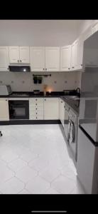 cocina con armarios blancos y suelo de baldosa blanca en Marina smir, en Marina Smir