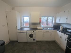 a kitchen with a washing machine and a sink at The Noisy Rooms in Southampton