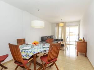 a dining room with a table and chairs and a room with a couch at Apartment Ronda Creixell by Interhome in Creixell