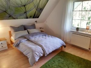 a bedroom with a large bed with a green rug at Ferienwohnung am Heidesee in Faßberg