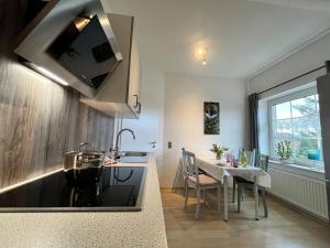 a kitchen with a table and a sink and a stove at Ferienwohnung am Heidesee in Faßberg +12 photos