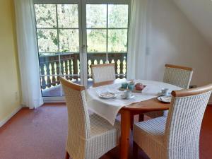 a dining room with a table with chairs and a window at Ferienwohnung am Heidesee in Faßberg