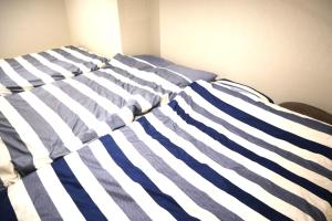 a bed with blue and white stripes on it at Shibuya Stay Tokyo A101 in Tokyo