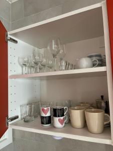 a cupboard filled with wine glasses and bowls at Elegante Apartmento nel centro storico di Treviso in Treviso