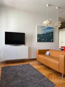 a living room with a couch and a flat screen tv at Elegante Apartmento nel centro storico di Treviso in Treviso