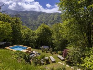 un jardin avec une piscine et des montagnes en arrière-plan dans l'établissement Villa Il Castagneto by Interhome, à Pisogne