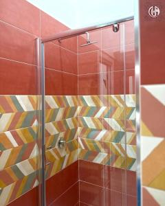 a shower with a glass door and colorful tiles at Ilaria e Giulia Rooms in Corbara +22 photos