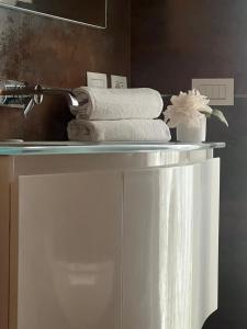 a shelf with towels on it in a bathroom at Comfortable apartment - Monza park with garage in Biassono