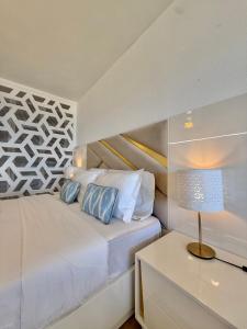 a bedroom with a bed and a table with a lamp at The View Costa Caparica in Costa da Caparica