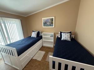 a bedroom with two beds and a window at Palm Haven Beach Side Villa in Holmes Beach
