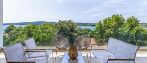 a balcony with chairs and a view of the water at Brand New Design Villa with Heated Pool and Sea view in Pomer