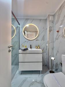 a bathroom with a white sink and a mirror at The View Costa Caparica in Costa da Caparica +9 photos