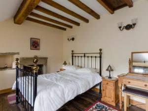 une chambre avec un grand lit et un piano dans l'établissement Highbury Cottage, à Hathersage 7 autres photos