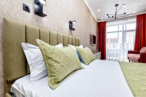 a bedroom with a large bed with green and white pillows at 1-комнатная квартира Кумисбекова 4, ЖК Altyn Tau in Astana