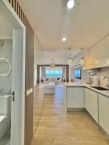 a kitchen with white cabinets and a living room at The View Costa Caparica in Costa da Caparica