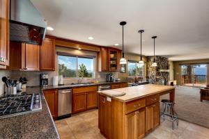 a large kitchen with wooden cabinets and a large window at Tudor Lodge home in Stateline