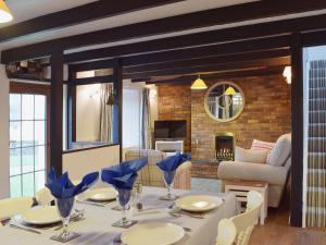 a dining room with a table and a living room at Ty Capel Seion in Cardigan