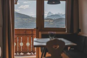 a room with a table and a window with mountains at HAUSERHOF Farmhouse with Dolomite View in Villandro