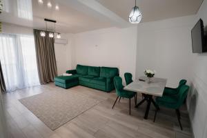 a living room with a green couch and a table at Ana Derol in Năvodari +2 photos