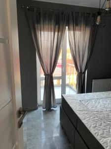 a bedroom with a bed and a large window at Nowoczesny apartament z dużym tarasem i widokiem na jezioro in Giżycko