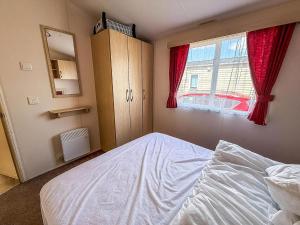a bedroom with a white bed and a window at Fantastic 6 Berth Caravan At Haven Skegness Holiday Park Ref 88028Hr in Skegness