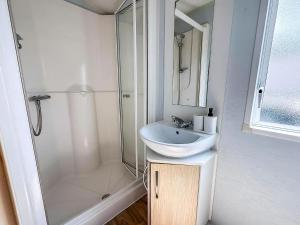 a white bathroom with a sink and a shower at Fantastic 6 Berth Caravan At Haven Skegness Holiday Park Ref 88028Hr in Skegness +10 photos